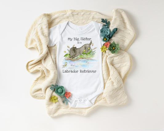 Baby onesie with a Labrador Retriever illustration and text, surrounded by decorative flowers on a white background.