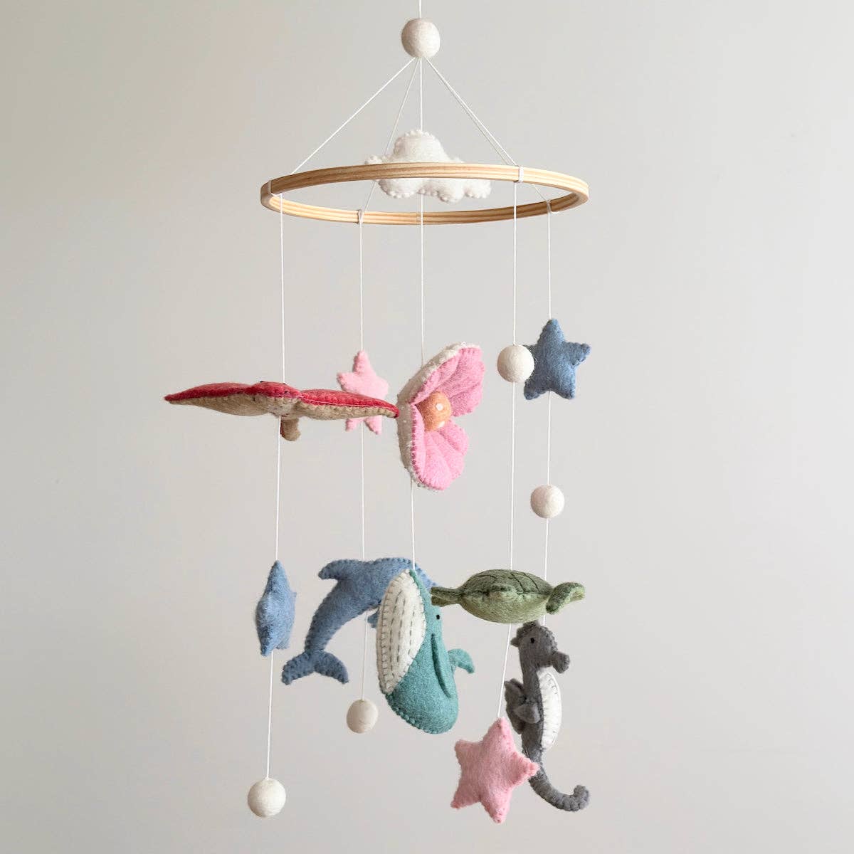 Baby mobile with sea-themed toys hanging from a circular frame against a plain background