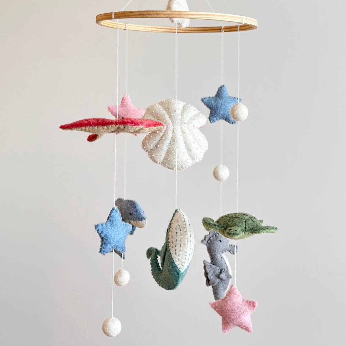 Baby mobile with sea-themed decorations on a plain background