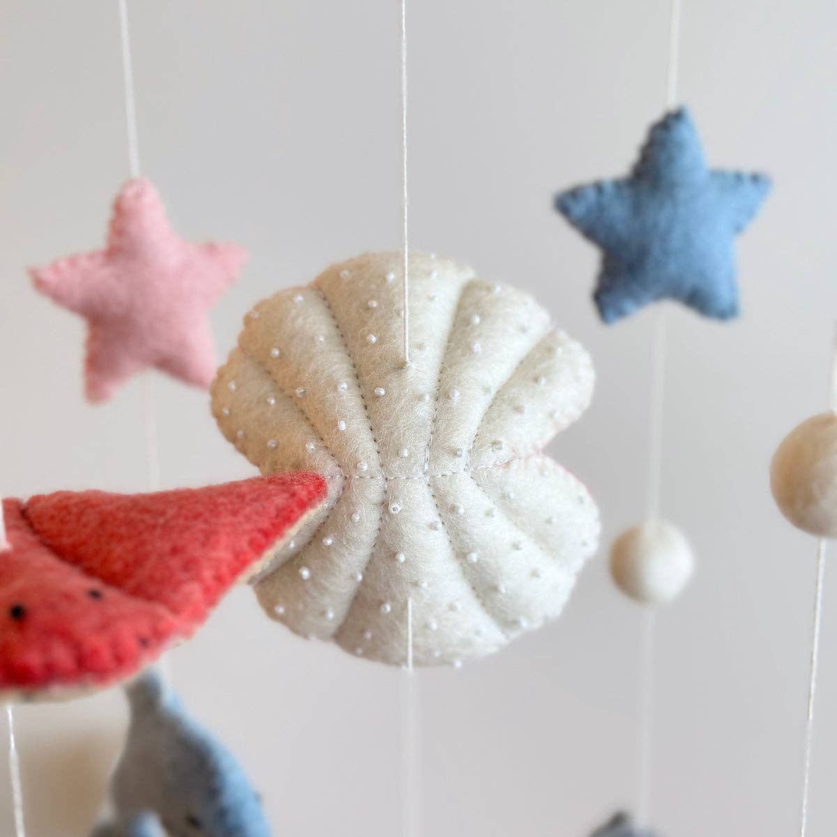 Felt sea-themed mobile with stars and shells on a white background