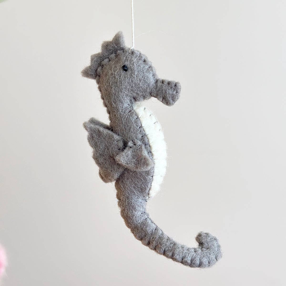 Gray plush seahorse toy on a white background