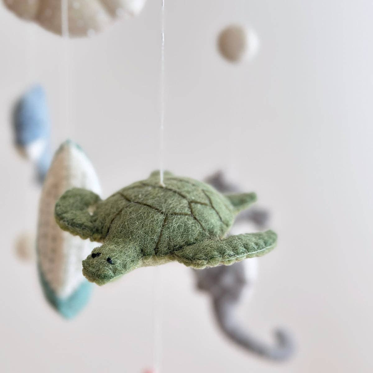 Green turtle-shaped tea bag on a white background