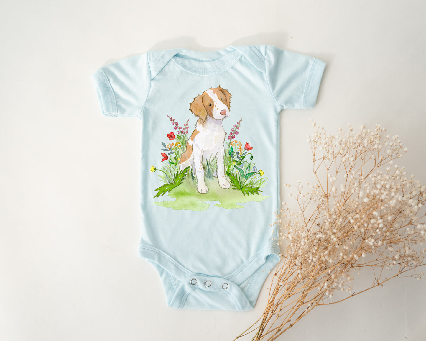Light blue baby onesie with a dog illustration on a white background