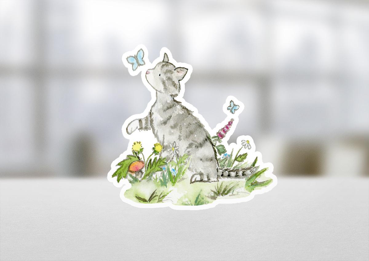 Sticker of a cat among flowers and butterflies on a white surface with a blurred background