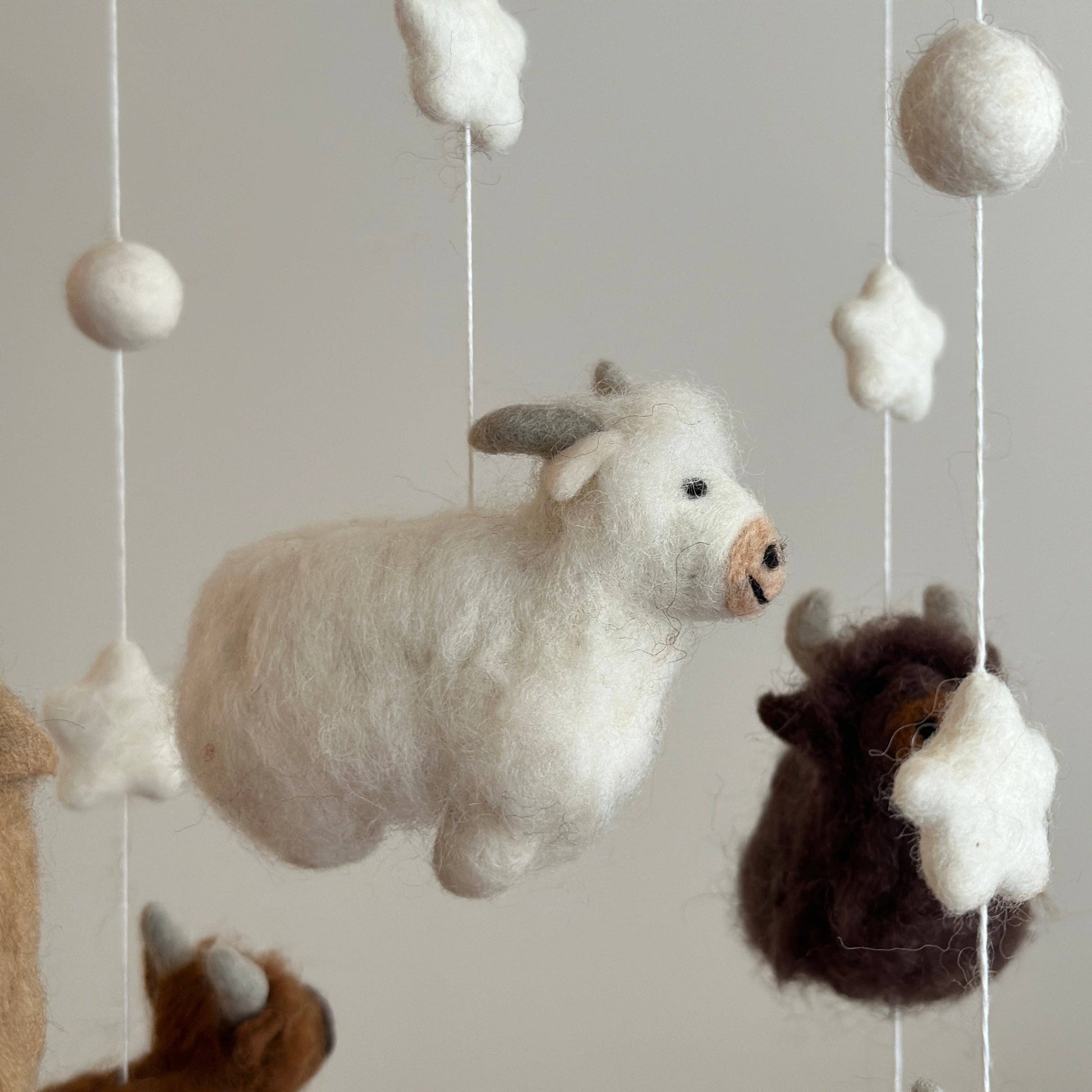close up of white highland cow on baby mobile