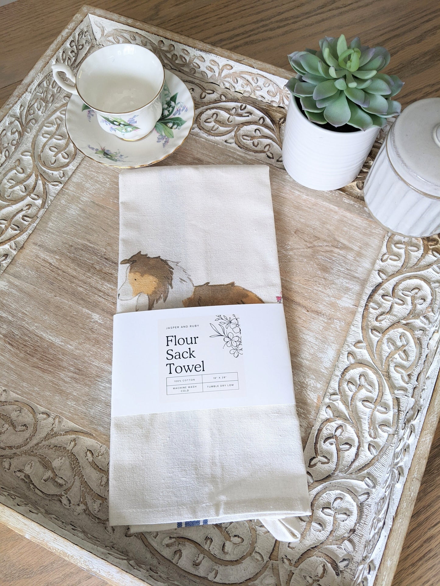 Farmhouse cotton tea towel with blue stripes and artwork of sable shetland sheepdog and flowers.