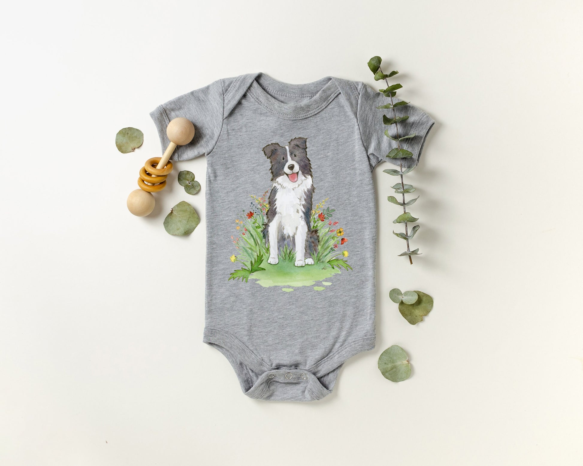 Baby bodysuit with a black and white border collie picture printed on it.