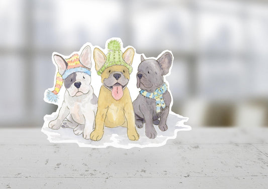 vinyl sticker with three Frenchie pups all wearing festive hats and scarves