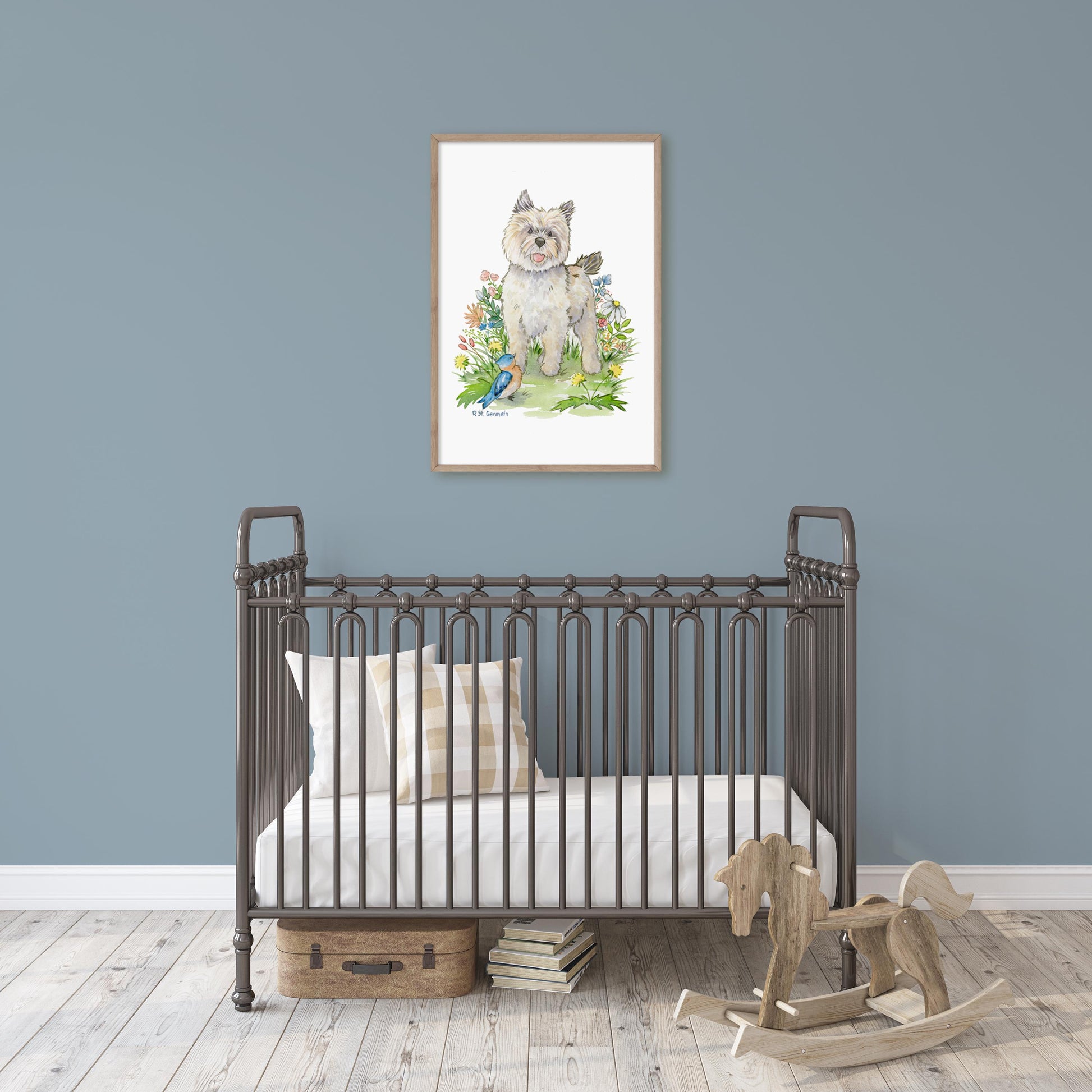 Large framed watercolor painting of cairn terrier puppy, bluebird, and colorful flowers hanging above a crib in a baby's nursery.
