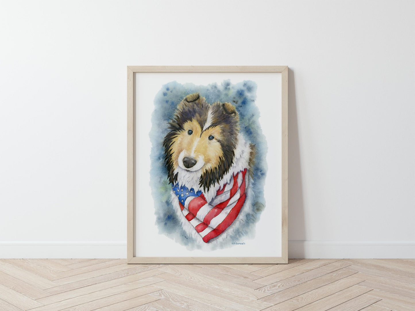 Framed artwork of a sheltie wearing an American flag bandana on a white wall.
