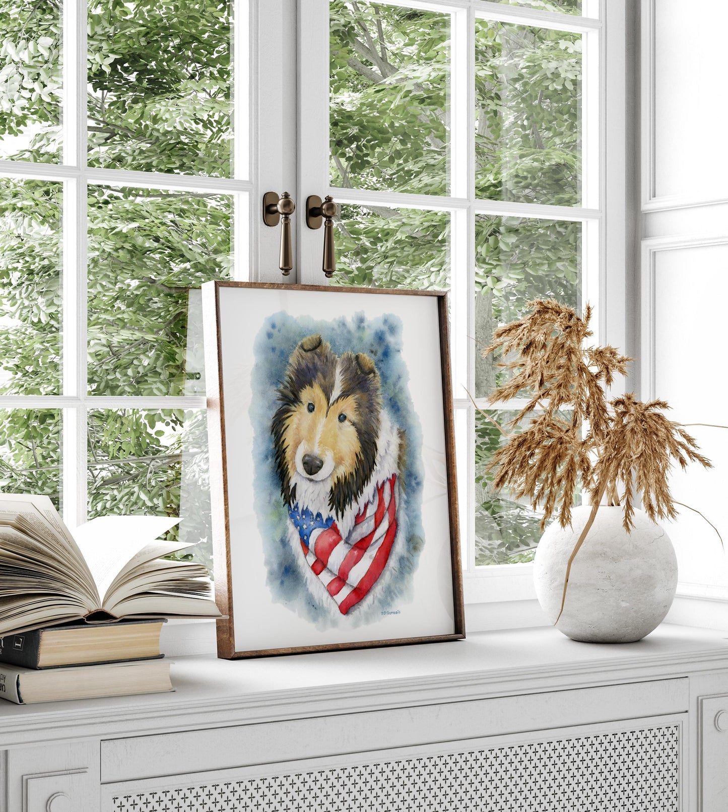 Framed artwork of a dog with an American flag design on a windowsill with books and a vase.