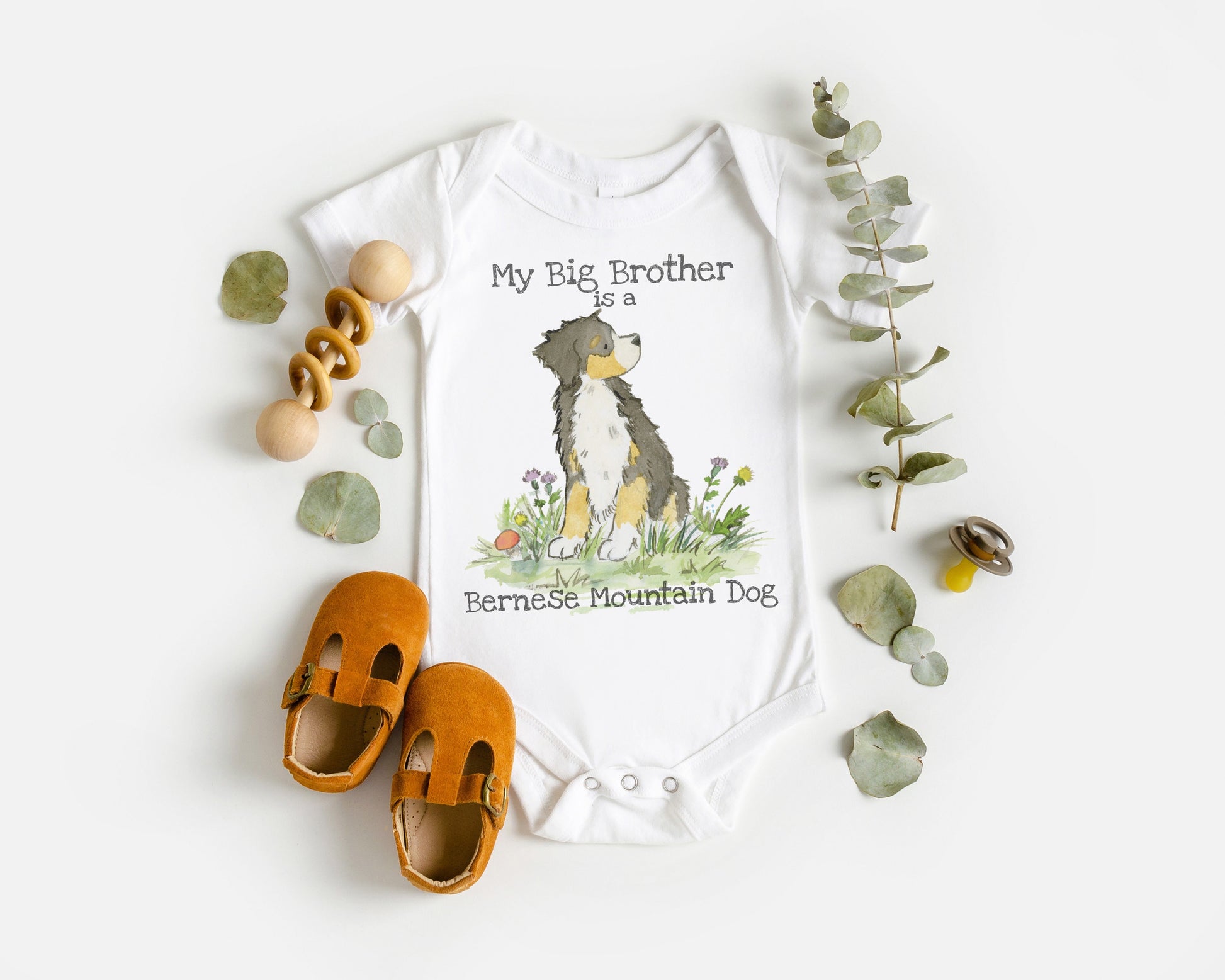 White infant bodysuit with artwork of a cute Bernese Mountain Dog and the words "My big brother is a Bernese Mountain Dog".