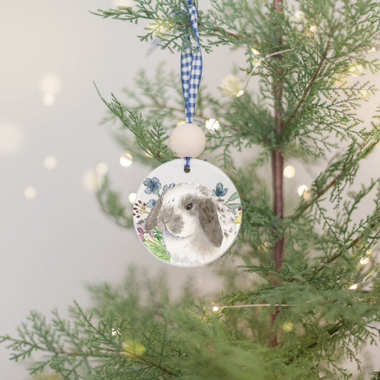 White ceramic ornament with watercolor painting of grey and white spotted Holland Lop bunny rabbit and colorful wildflowers.