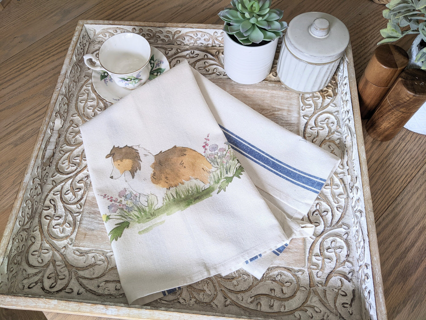 Farmhouse cotton tea towel with blue stripes and artwork of sable shetland sheepdog and flowers.