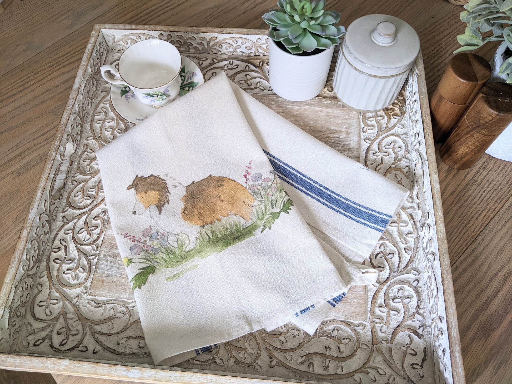Farmhouse cotton tea towel with blue stripes and artwork of sable shetland sheepdog and flowers.