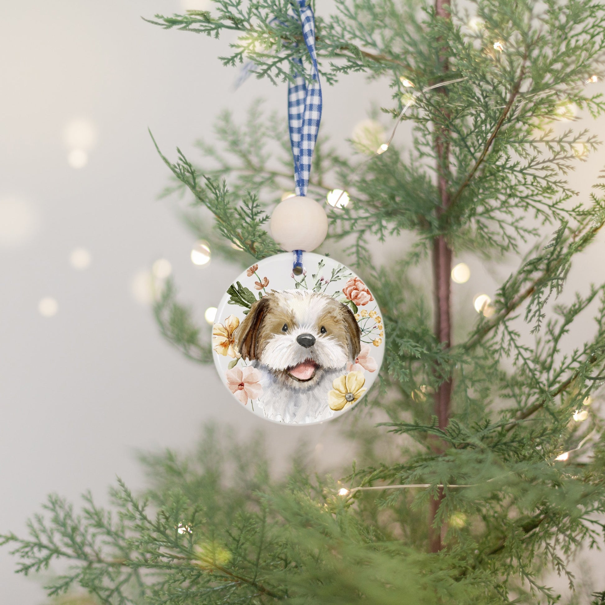 Ceramic circle ornament with watercolor artwork of a happy brown and white shih tzu dog and colorful flowers.