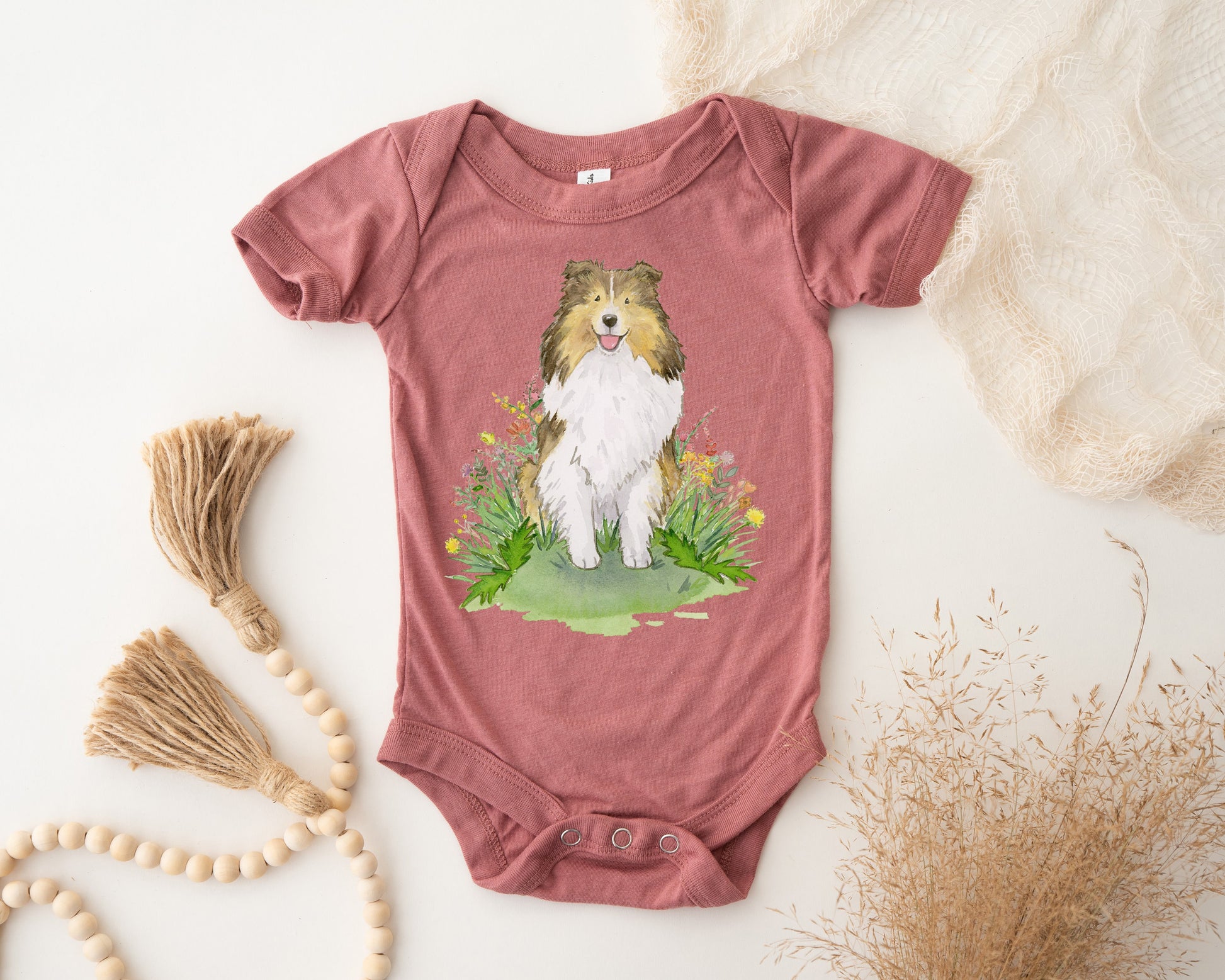 Baby bodysuit with cute sable sheltie puppy on it