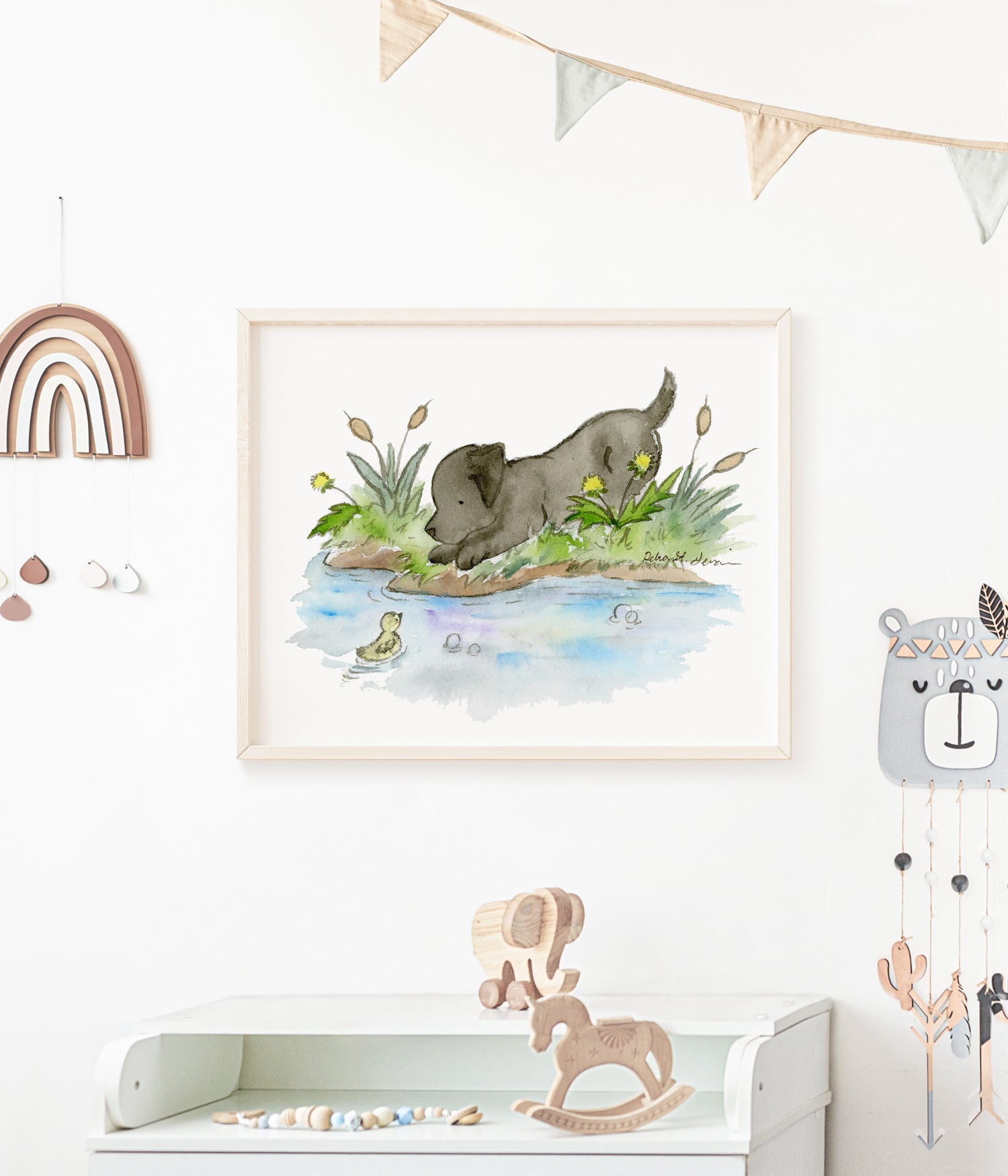 watercolor painting of black lab puppy hanging in a baby nursery