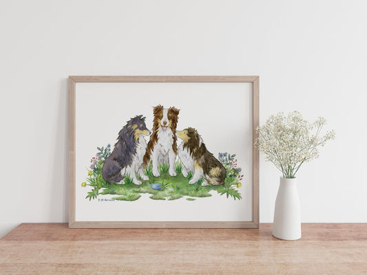 A framed painting of two cute shetland sheepdogs and an australian shepherd sitting in a patch of colorful flowers.