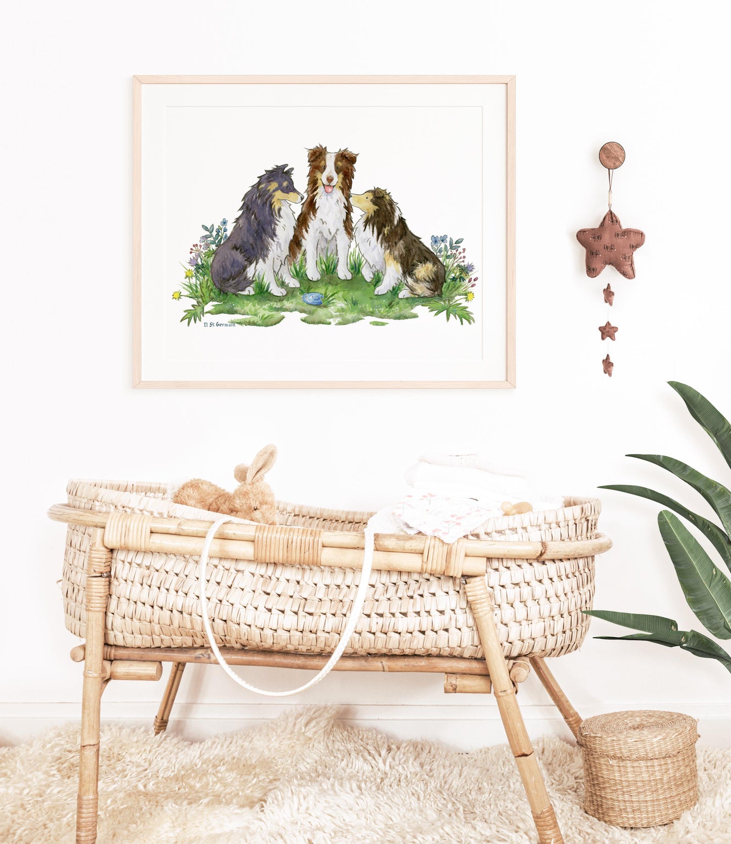 A framed painting of two cute shetland sheepdogs and an australian shepherd sitting in a patch of colorful flowers hanging in a baby&#39;s nursery.
