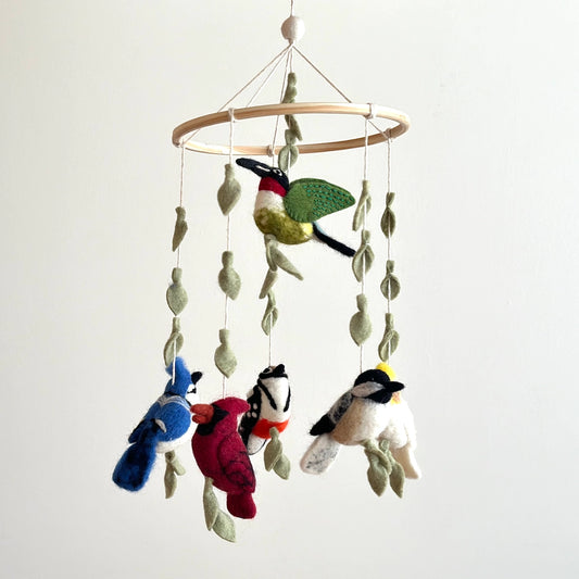 Bird-themed mobile with colorful birds and leaves on a plain background