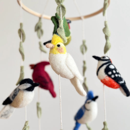 Felt bird mobile with colorful birds on a plain background