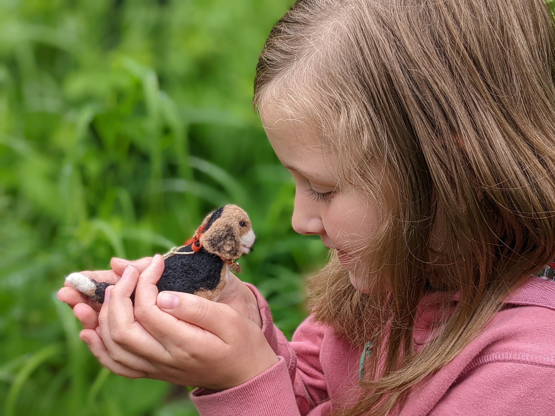 child holding felted beagle puppy toy