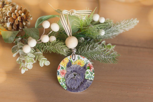 Black Brussels Griffon dog with flowers on a ceramic ornament.