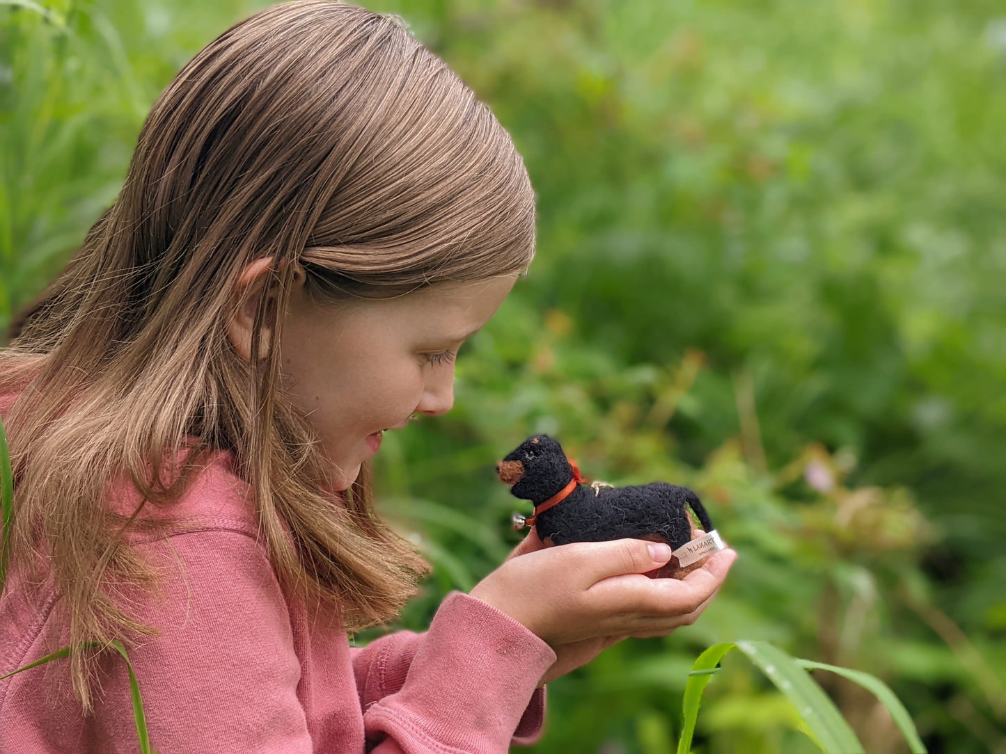 child holding tiny dachshund wool felted toy
