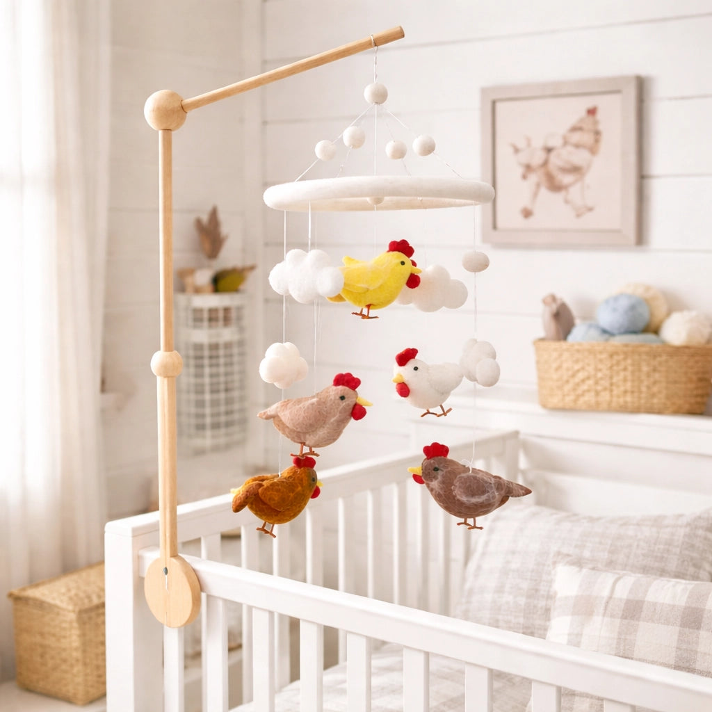 Baby crib with a mobile featuring chickens and clouds in a nursery setting.