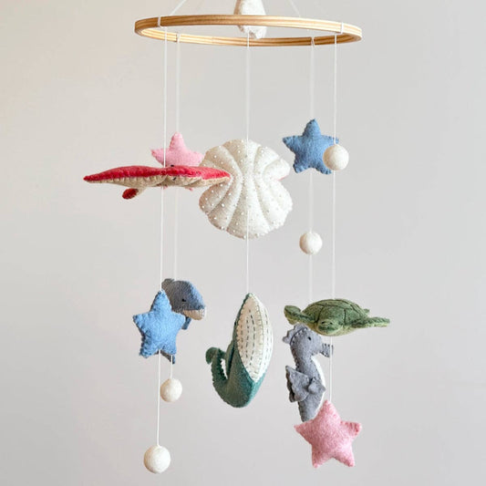 Baby mobile with sea-themed decorations on a plain background