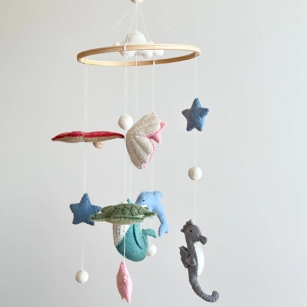 Children's mobile with sea-themed decorations on a plain background