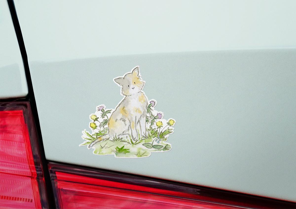 Sticker of a cat among flowers on a car's rear window