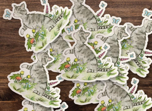 Stickers of cats with floral designs on a wooden surface