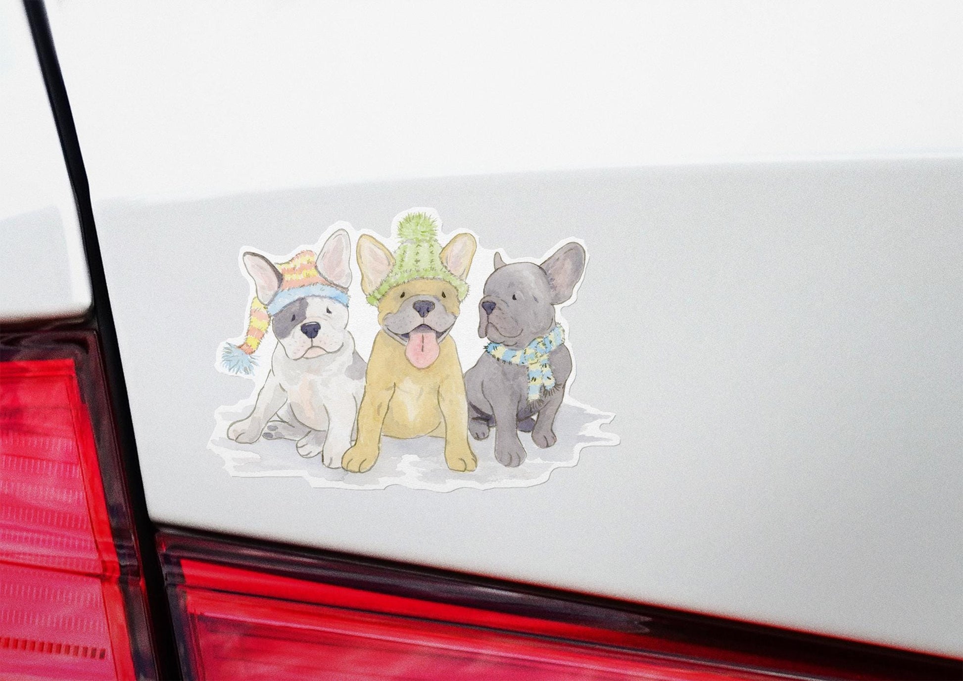 vinyl sticker with three  Frenchie pups all wearing festive hats and scarves