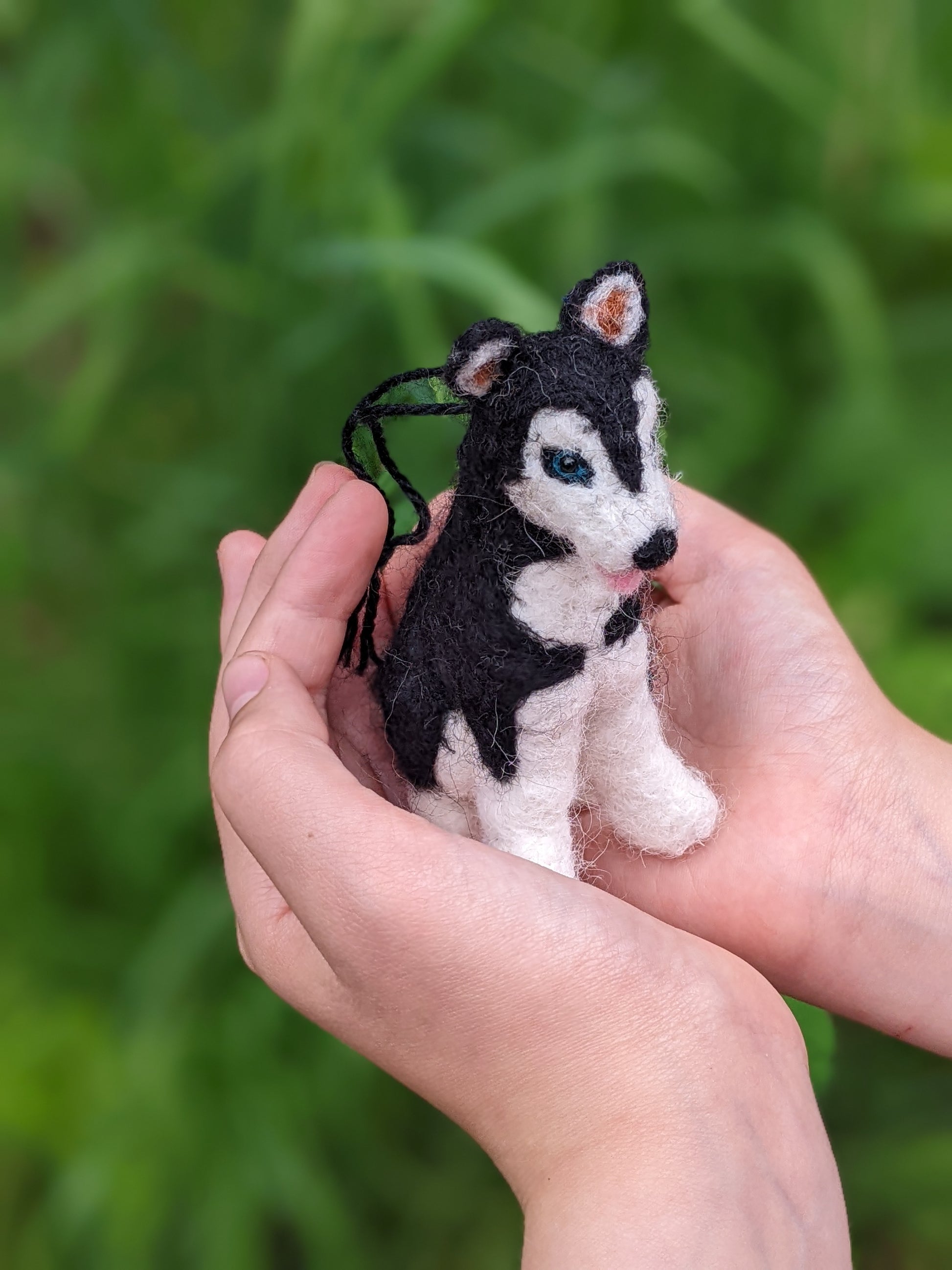 little needle felted wool husky held in child's hands