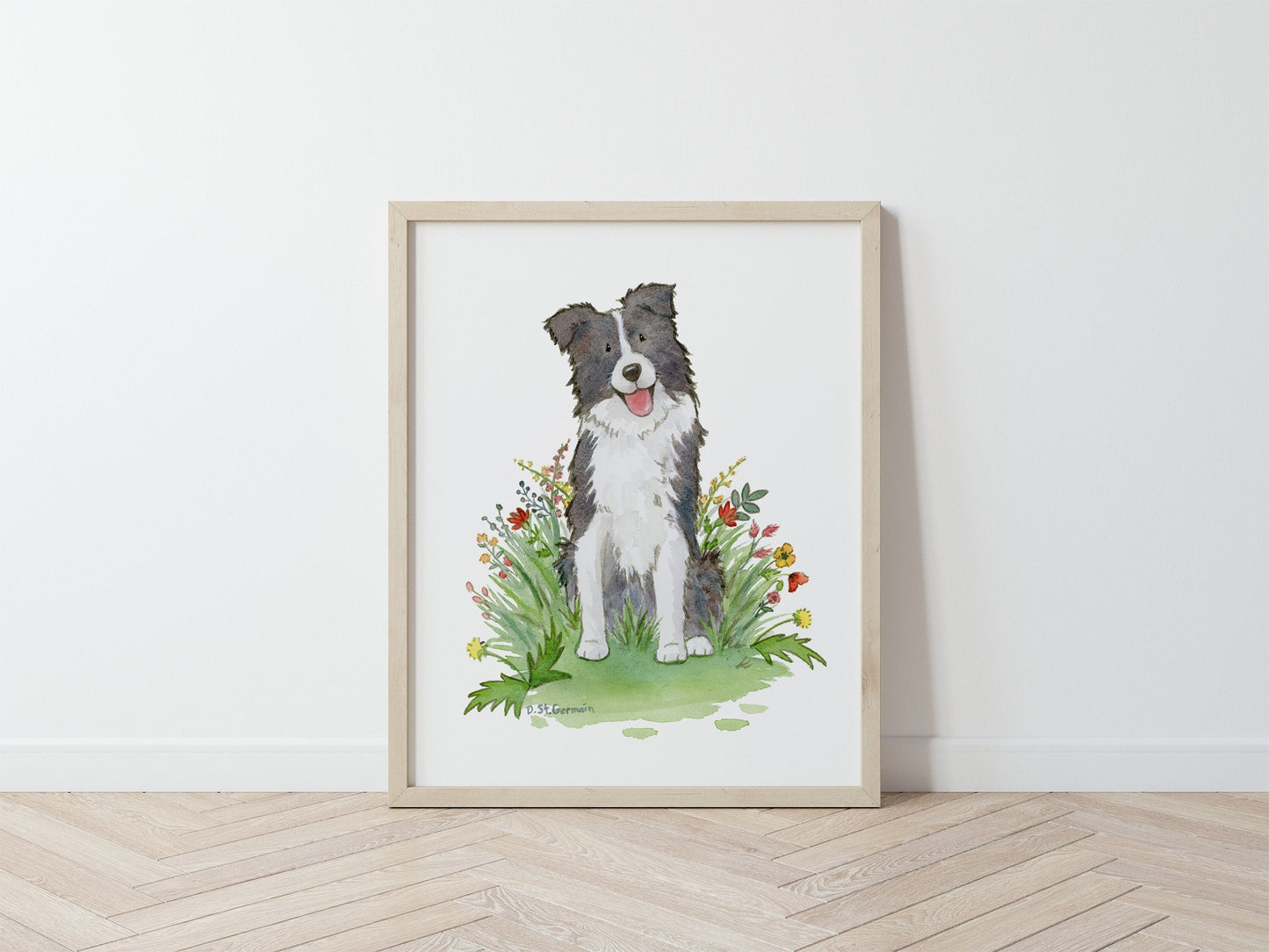 Framed print of a happy black and white border collie dog sitting in a patch of red and yellow wildflowers.