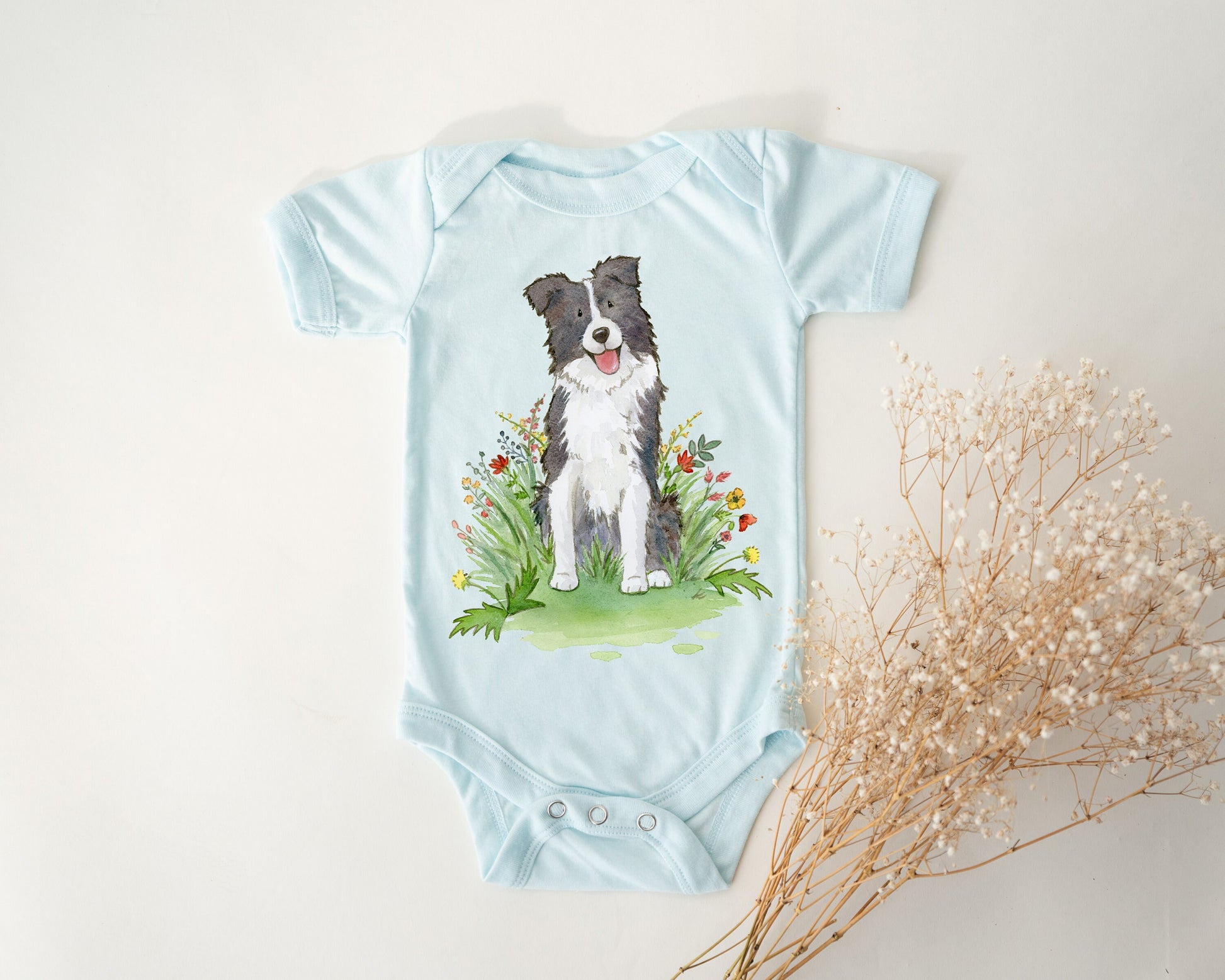 Baby bodysuit with a black and white border collie picture printed on it.