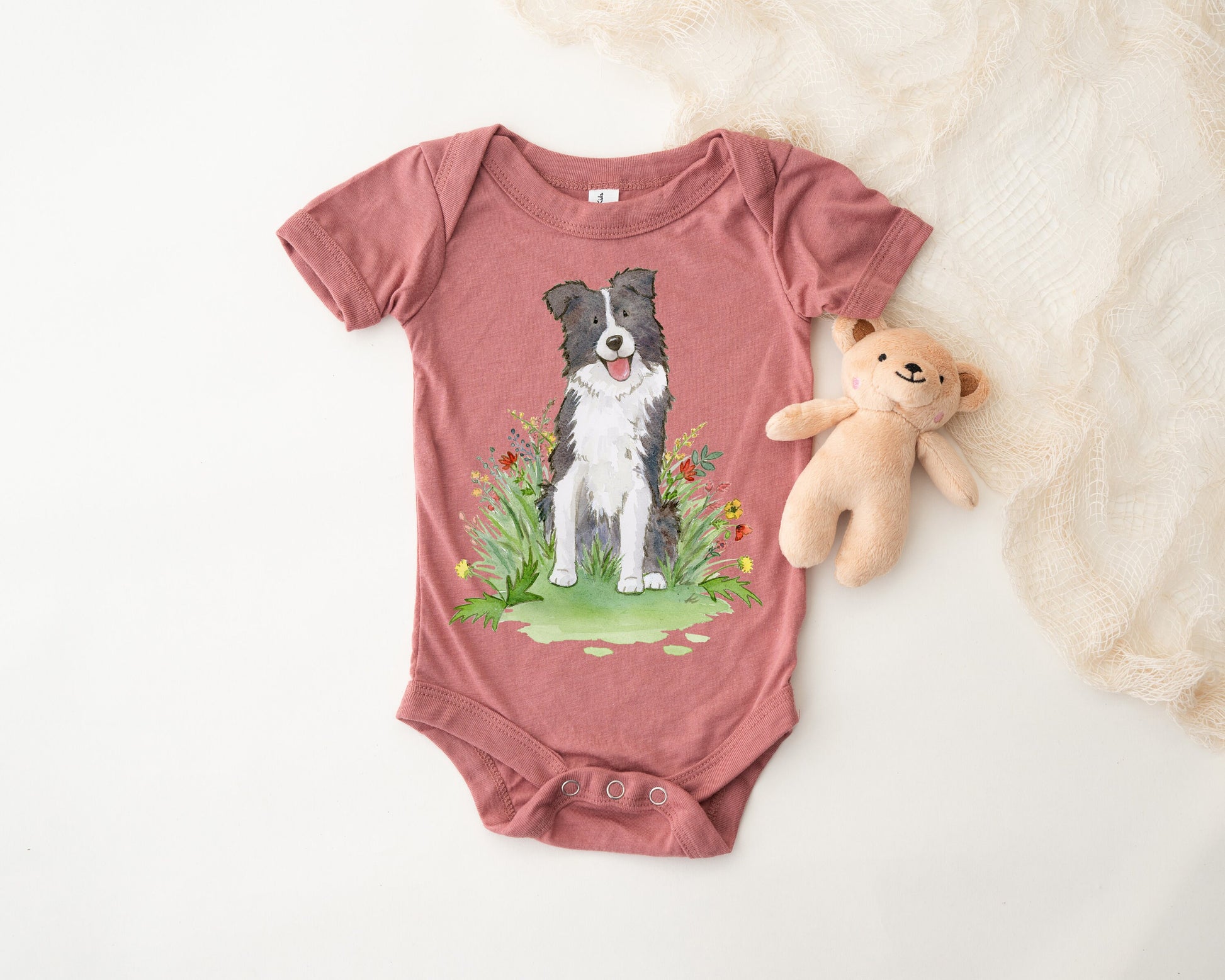 Baby bodysuit with a black and white border collie picture printed on it.
