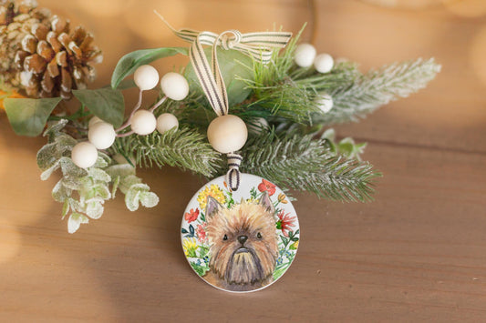 Red Brussels Griffon dog with flowers on a ceramic ornament.