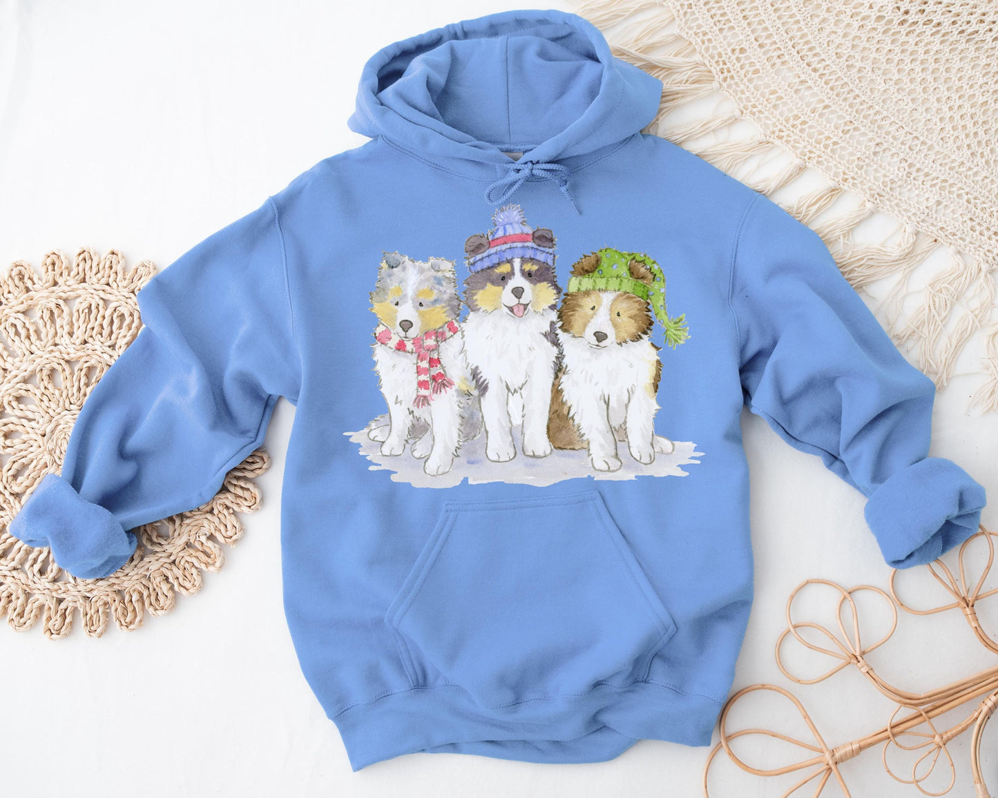 Hooded sweatshirt with three sheltie puppies wearing winter hats and scarves.