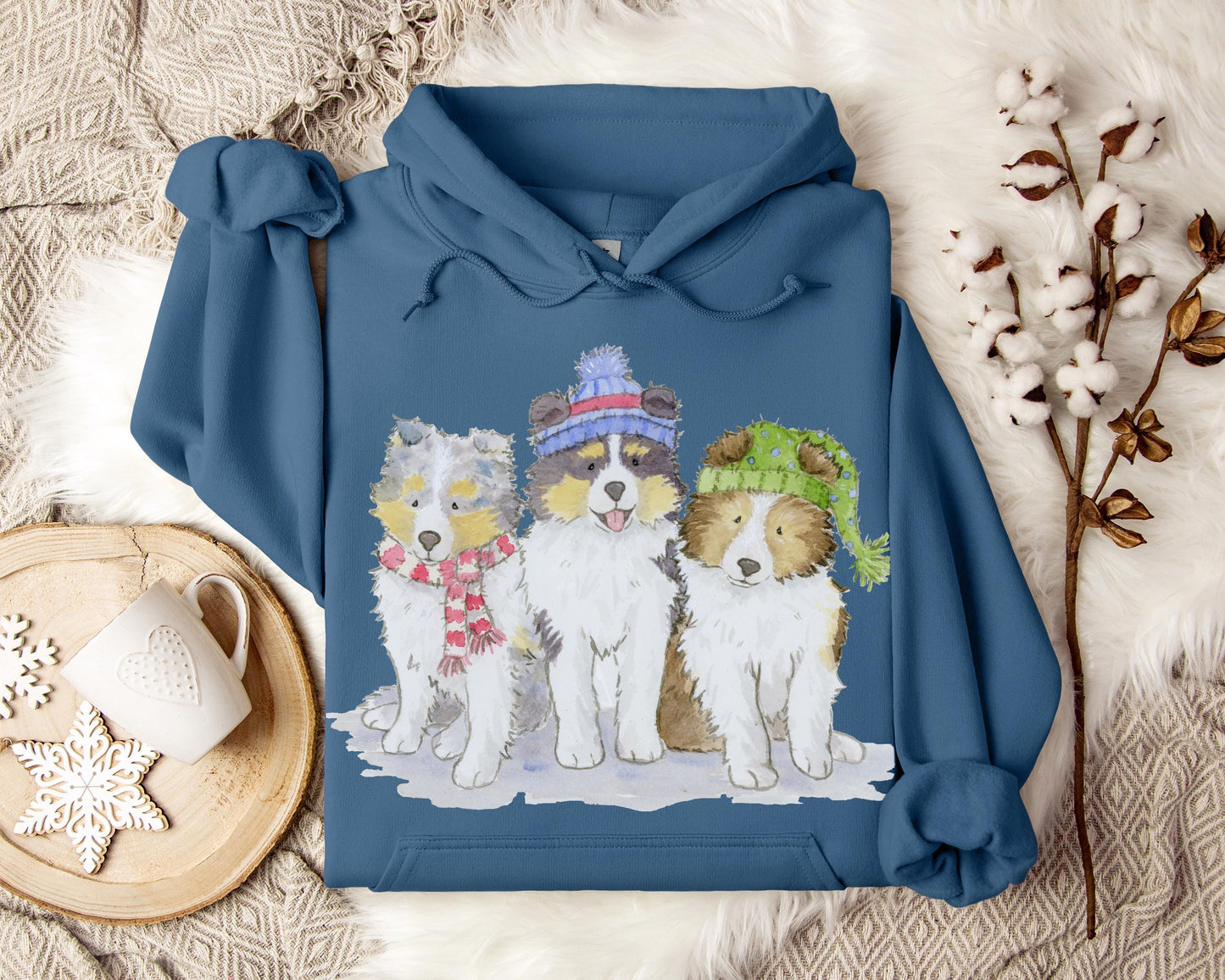 Hooded sweatshirt with three sheltie puppies wearing winter hats and scarves.