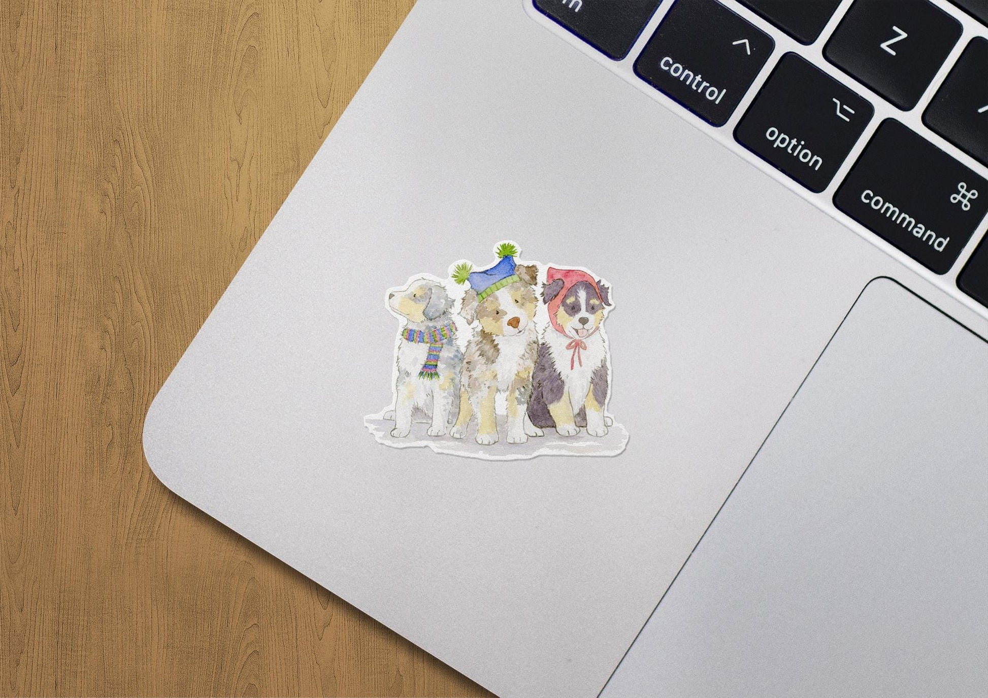 vinyl stickers with Australian Shepherd pups wearing festive hats and scarves on a laptop