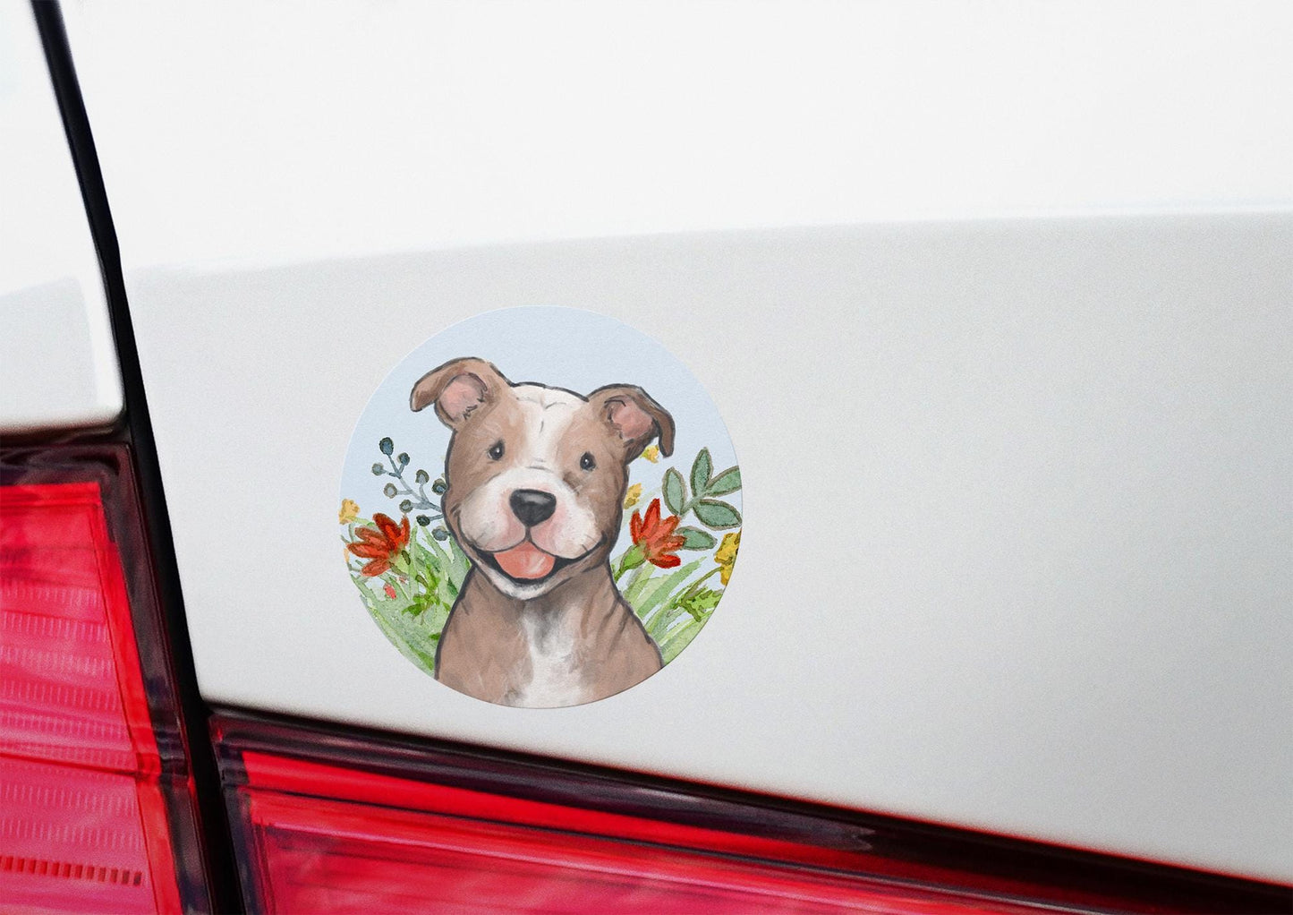 Circle sticker with a happy pitbull dog and flowers on a light blue background.