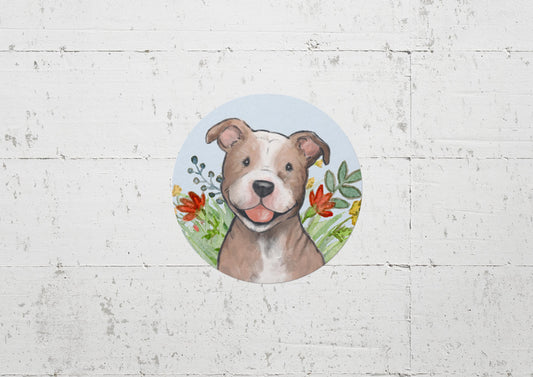 Circle sticker with a happy pitbull dog and flowers on a light blue background.