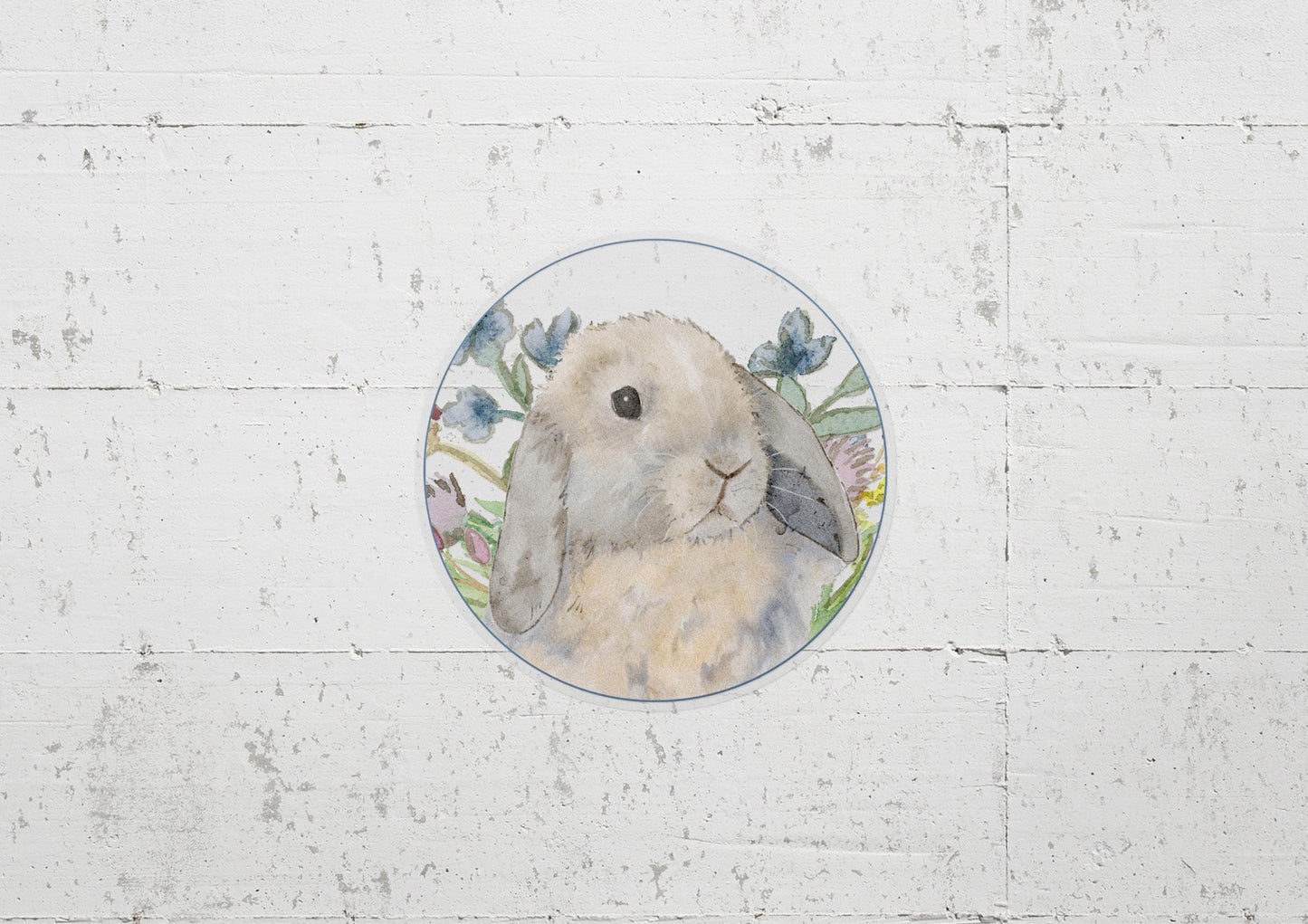 Circle sticker with a blue tort holland lop bunny and flowers on it.