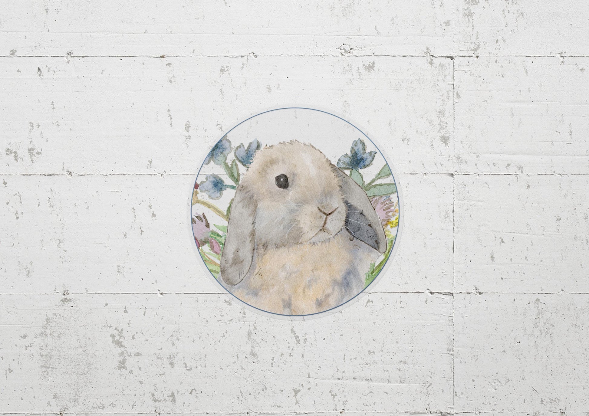 Circle sticker with a blue tort holland lop bunny and flowers on it.