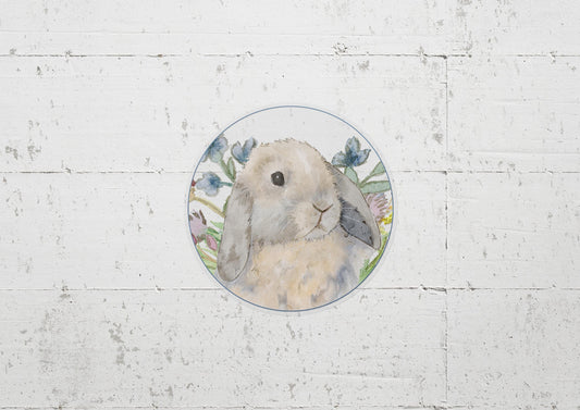 Circle sticker with a blue tort holland lop bunny and flowers on it.