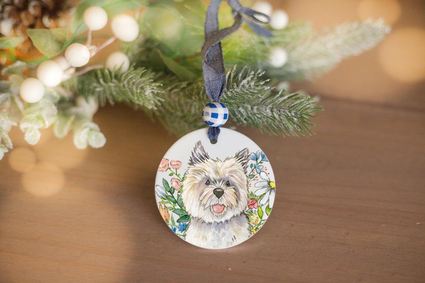 Cairn terrier and colorful flowers on a ceramic ornament.