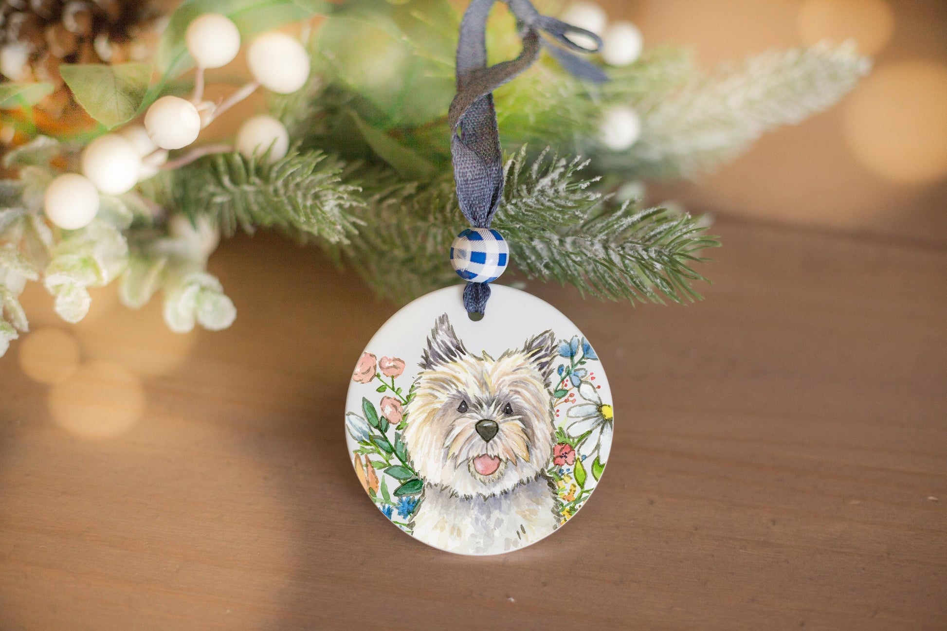 Cairn terrier and colorful flowers on a ceramic ornament.